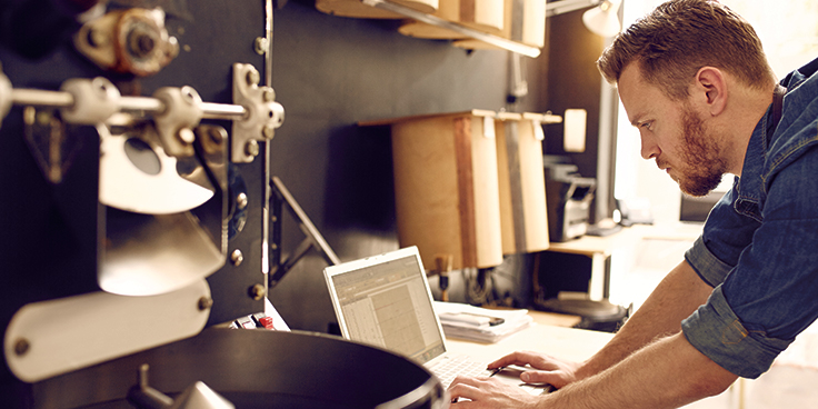 Small business owner checking energy use on laptop